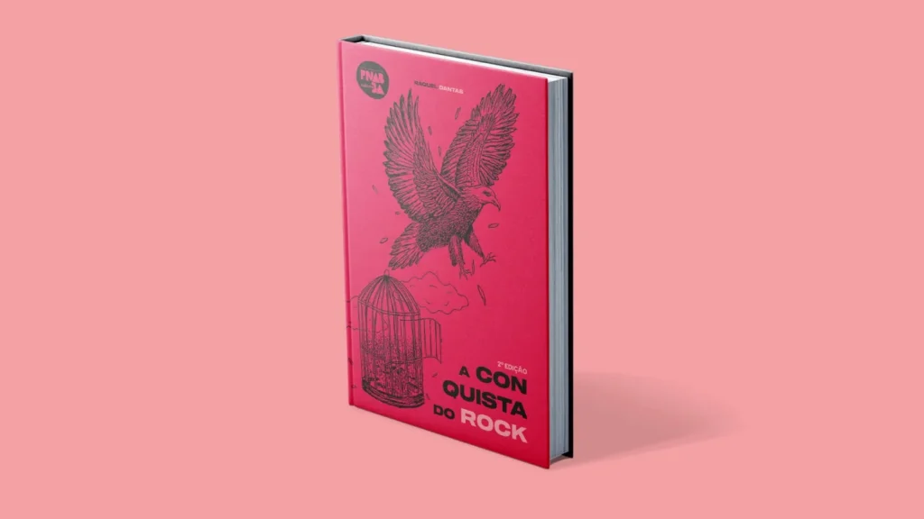 Livro de capa dura na cor rosa sobre um fundo rosa. A capa traz a ilustração em traços pretos de uma grande ave com asas abertas voando acima de uma gaiola aberta com pássaros saindo de dentro dela. O título na capa é A Conquista do Rock.